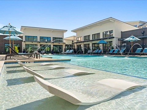 a swimming pool with two lounge chairs and umbrellas